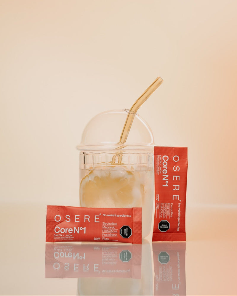 Vaso con OSERE CoreN°1 ya preparado, con hielo y pitillo, junto a la caja y un sachet