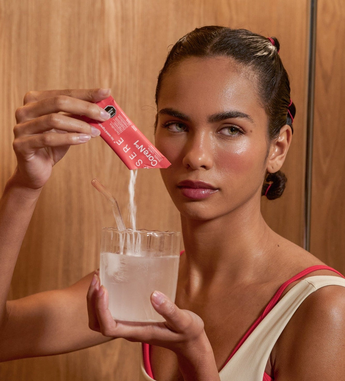 Persona vertiendo un sachet de OSERE CoreN°1 en un vaso con agua